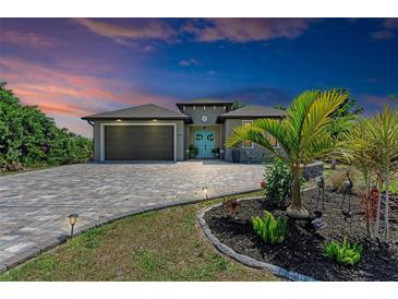 One-story home with teal door, paver driveway, and landscaped yard at 237 Albatross Rd, Rotonda West, FL 33947