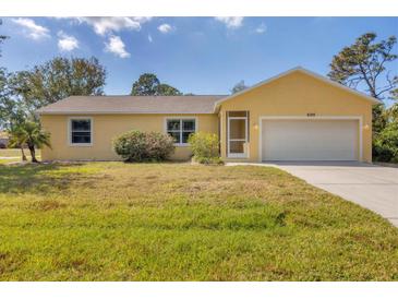 Charming yellow single-story home with attached two-car garage and well-maintained lawn at 6125 Higgins Ln, Englewood, FL 34224