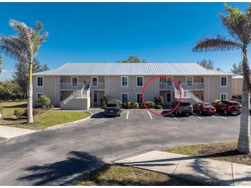 Ground-level condo building with parking and tropical landscaping at 9900 Fiddlers Green Cir # 137, Rotonda West, FL 33947