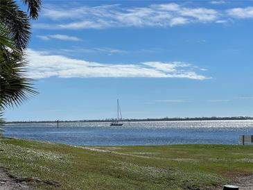 Scenic waterfront view with a sailboat on sparkling water and clear skies at 11000 Placida Rd # 101, Placida, FL 33946