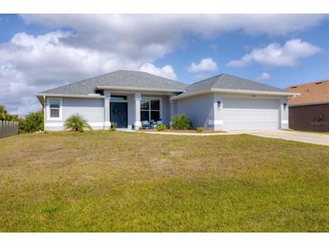 Charming single-story home featuring a two-car garage, well-maintained lawn, and inviting front entrance at 13951 Allamanda Cir, Port Charlotte, FL 33981