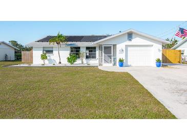 Charming single-story home with well-maintained lawn, solar panels, and inviting curb appeal at 1586 Overbrook Rd, Englewood, FL 34223