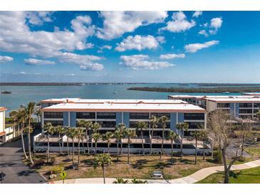 Beautiful waterfront condominium with balconies and palm trees in front of the building at 1651 Beach Rd # 301, Englewood, FL 34223