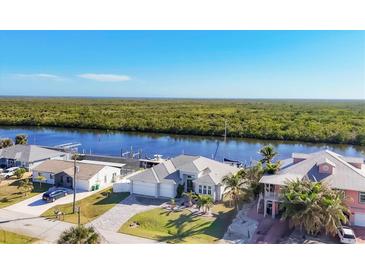 A beautiful waterfront home featuring a private boat dock, lush landscaping and gorgeous water views at 18502 Arapahoe Cir, Port Charlotte, FL 33948