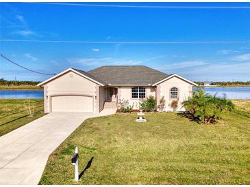 Charming single-Gathering home featuring a well-manicured lawn, garden, and attached garage by the water at 43 Blue Hen Dr, Placida, FL 33946