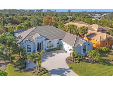 Beautiful single-story home featuring a paver driveway and lush landscaping in a desirable neighborhood at 15 Boca Royale Blvd, Englewood, FL 34223