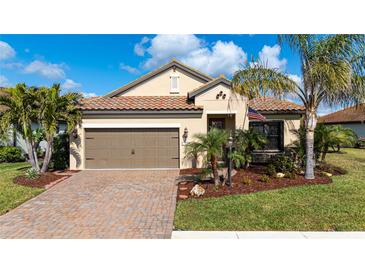 Charming single-story home featuring a well-manicured lawn, mature landscaping, and a brick-paved driveway at 209 Malina Ct, Nokomis, FL 34275