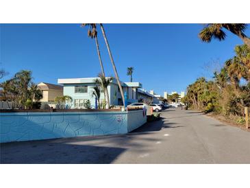 Light blue two story property with palm trees on a sunny day at 5055 N Beach Rd # 203, Englewood, FL 34223