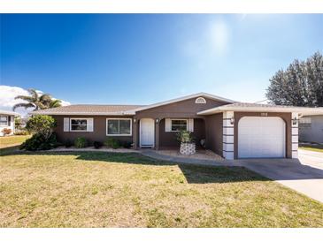 Charming single-story home featuring a well-maintained lawn, neutral paint, and attached garage at 1918 Greenlawn Dr, Englewood, FL 34223