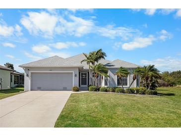 Charming single-story home featuring a well-maintained lawn and lush tropical landscaping at 194 Sunset Rd, Rotonda West, FL 33947