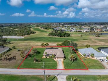 Beautiful aerial view of home with golf course in background, surrounded by lush landscaping at 934 Rotonda Cir, Rotonda West, FL 33947