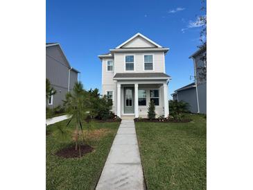 Two-story house with light beige siding, gray door, and landscaping at 9031 Duany Ln, Lakewood Ranch, FL 34240