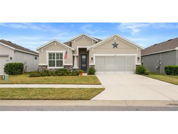 One-story home with a neutral color scheme and a two-car garage at 813 Old Windsor Way, Spring Hill, FL 34609