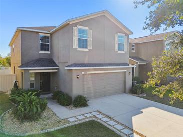 Two-story house with neutral exterior, attached garage, and landscaping at 13752 Reindeer Cir, Hudson, FL 34669