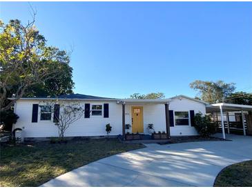 Charming white house with yellow door, landscaping, and a long driveway at 4701 22Nd N Ave, St Petersburg, FL 33713