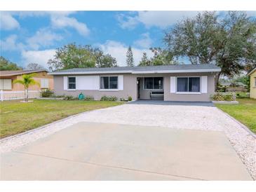 Gray house with white shutters, gravel driveway, and small front yard at 4760 84Th N Ter, Pinellas Park, FL 33781