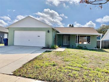 Charming single-story home featuring an attached garage and well-maintained lawn at 7644 Arlight Dr, New Port Richey, FL 34655