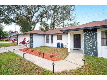 Newly renovated home with a stone facade and a well-maintained lawn at 1413 Sandalwood Dr, Plant City, FL 33563