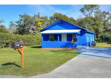 Charming blue house with a well-maintained lawn and a driveway at 1106 Powell St, Plant City, FL 33563