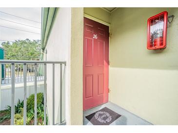 Inviting condo entry with a red door and a decorative welcome mat at 1799 N Highland Ave # 26, Clearwater, FL 33755