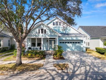 Light blue house with white columns, two-car garage, and manicured landscaping at 9713 Royce Dr, Tampa, FL 33626