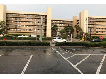 Exterior view of a condominium building with parking lot at 14900 Gulf Blvd # 113, Madeira Beach, FL 33708