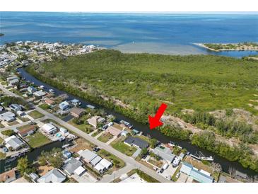 Aerial view of a waterfront home with boat dock on canal leading to a large body of water at 3215 W Shell Point Rd, Ruskin, FL 33570