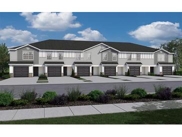 New townhome with gray siding, dark roof, and attached garages at 2763 Walden Town Cir, Plant City, FL 33566