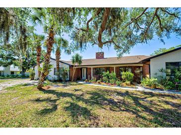 Charming brick home with mature landscaping and a welcoming front entrance shaded by mature trees at 1061 Owl Dr, Englewood, FL 34223