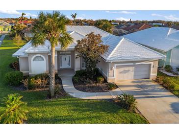 Single-story home with tile roof, attached garage, and landscaped lawn at 664 Silk Oak Dr, Venice, FL 34293