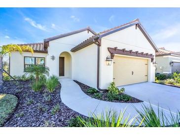 Single-story home with a two-car garage and landscaped front yard at 377 Ariano Ave, Nokomis, FL 34275