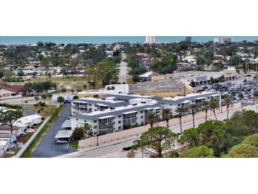 Aerial view of a condo building near the beach with parking and nearby businesses at 708 Tamiami S Trl # 308, Venice, FL 34285