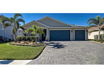 Attractive home with gray siding, landscaping, and paver driveway at 589 Mistiflower Cir, Nokomis, FL 34275