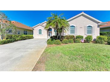 One-story home with a landscaped lawn and driveway at 620 Lakescene Dr, Venice, FL 34293