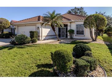 Single-story home with tile roof, landscaping, and a two-car garage at 444 Pinewood Lake Dr, Venice, FL 34285