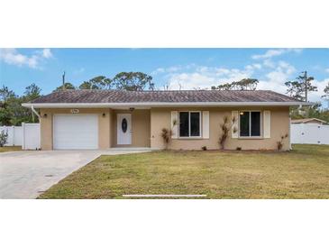 Tan house with white garage door and landscaping at 5296 Rolla Rd, Venice, FL 34293