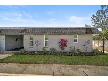 Gray exterior condo with well-manicured landscaping and a paved walkway at 4160 Fruitville Rd # 14, Sarasota, FL 34232