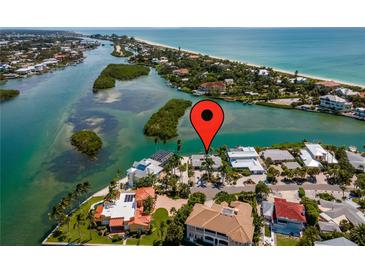 Aerial view of waterfront home with pool, dock, and lush tropical landscaping near the ocean at 922 Casey Cove Dr, Nokomis, FL 34275