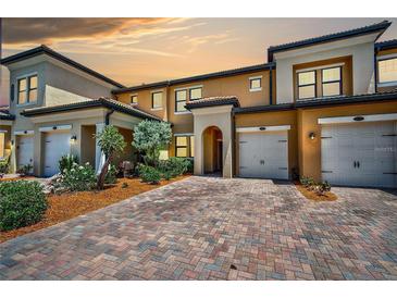 Townhome with two-car garage and brick paver driveway at 10055 Crooked Creek Dr # 102, Venice, FL 34293