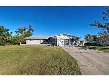 Ranch-style home with a large yard and screened porch at 1358 Leawood Rd, Englewood, FL 34223