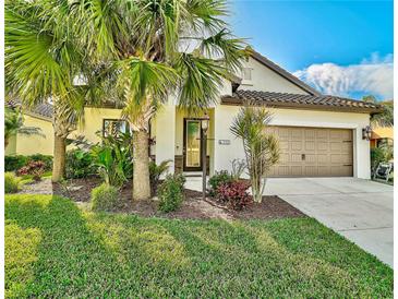Single-story home with a brown garage door and landscaped yard at 232 Benedetto Ct, Nokomis, FL 34275