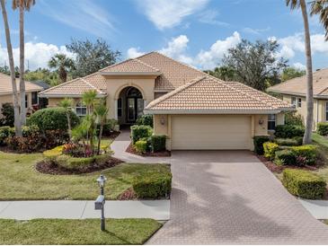 Single-story home with tile roof, landscaping, and paver driveway at 114 Medici Ter, North Venice, FL 34275