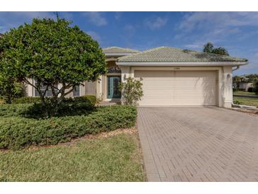 Single-story home with a two-car garage and landscaped front yard at 11584 Dancing River Dr, Venice, FL 34292