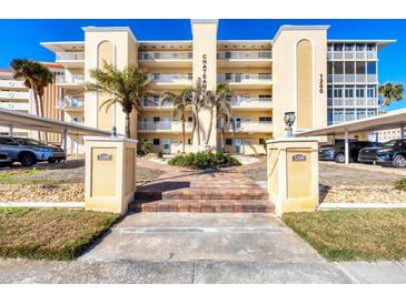 Beautiful building exterior with balconies, palm trees, and a covered parking area at 1200 Tarpon Center Dr # 108, Venice, FL 34285