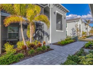 Landscaped backyard with walkway and tropical plants at 12440 Wellen Golf St # 208, Venice, FL 34293