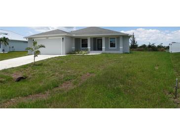 Newly constructed one-story home with attached garage and grassy yard at 14464 Fort Myers Ave, Port Charlotte, FL 33981