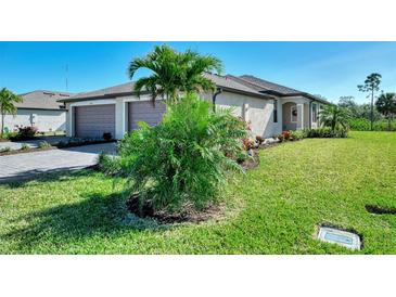 Landscaped front yard with palm trees and a paved driveway at 2160 Bonito Way, Port Charlotte, FL 33953