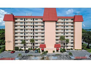 Front view of a tall residential building with red roof and ample parking at 232 Saint Augustine Ave # 404, Venice, FL 34285