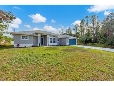 Single-story home with teal garage door and lush lawn at 3328 Waterloo Ter, North Port, FL 34286