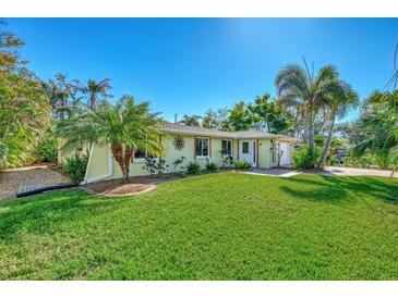 Well-maintained house with a lush lawn, palm trees, and a brick driveway at 3695 Shamrock Dr, Venice, FL 34293